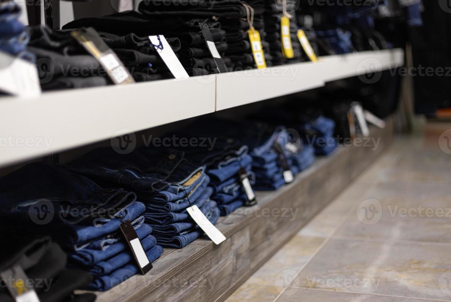 pila di jeans blu e neri in un negozio. foto