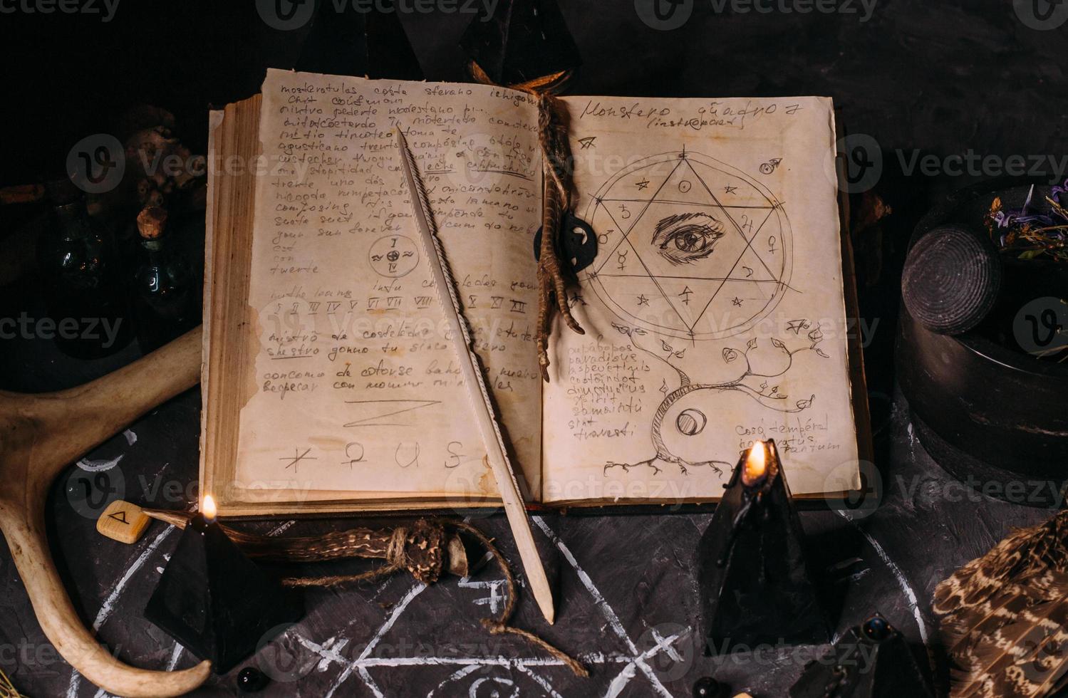 apri il vecchio libro con incantesimi, rune, candele nere sul tavolo delle streghe. concetto occulto, esoterico, divinatorio e wicca. foto