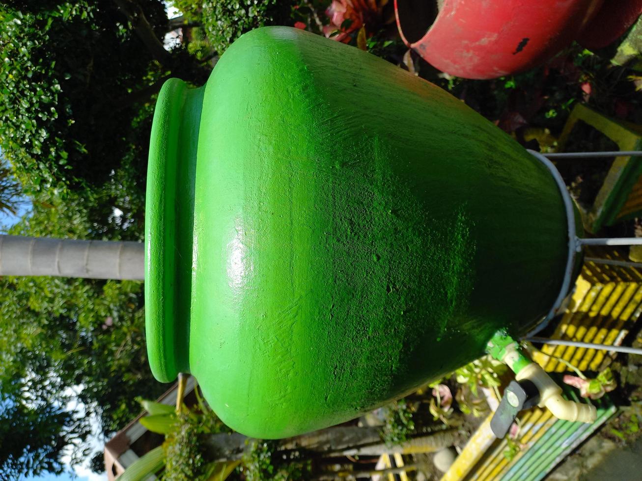 vecchio vaso verde che è stato convertito in un luogo per lavarsi le mani durante la pandemia. naturale. verde foto