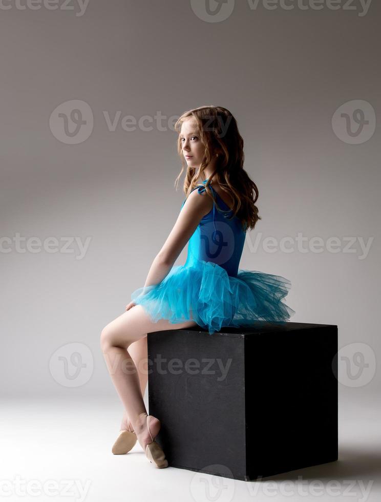 bella piccola ballerina in posa sul cubo in studio foto