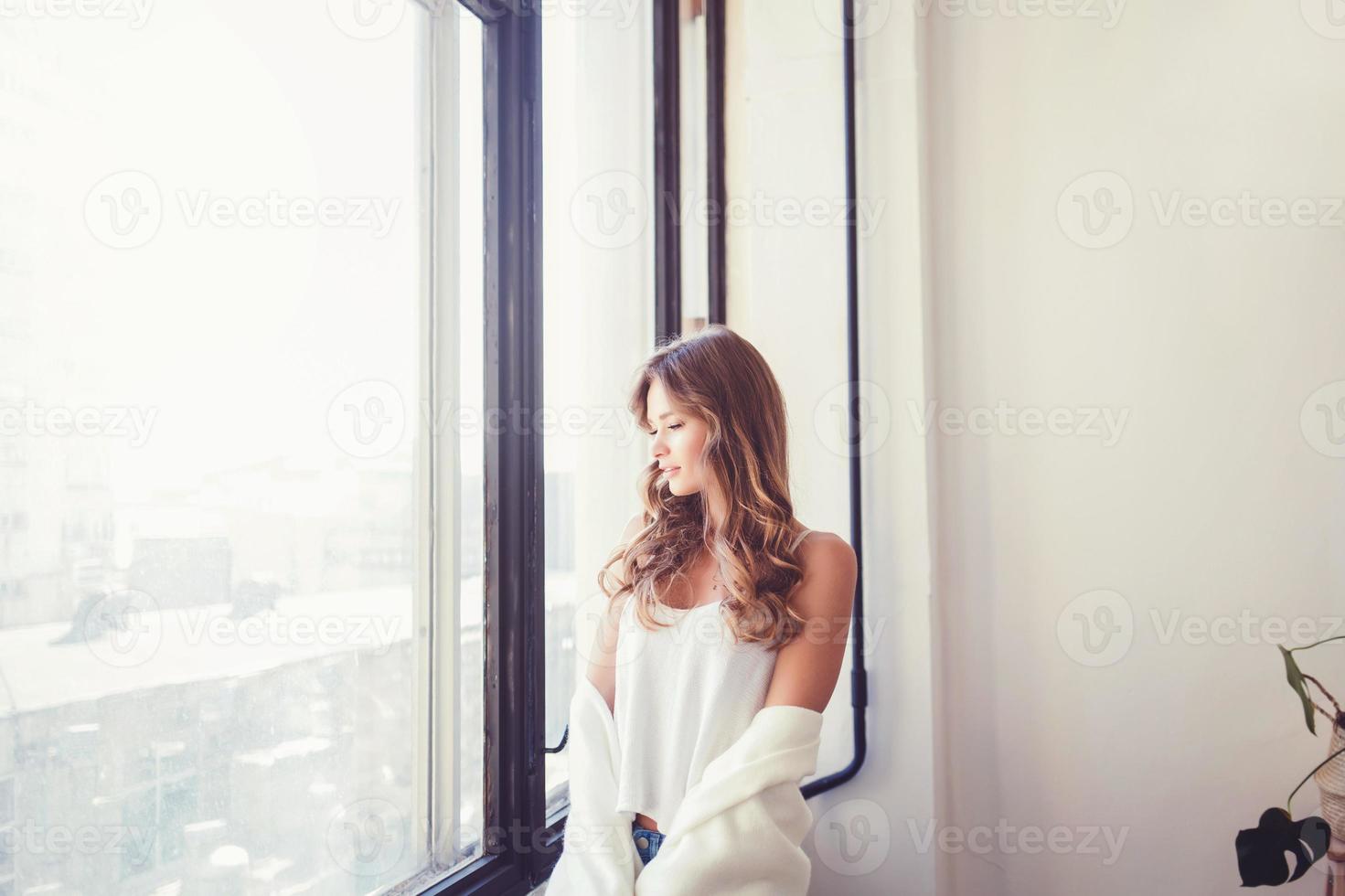 donna in maglietta vicino alla finestra foto