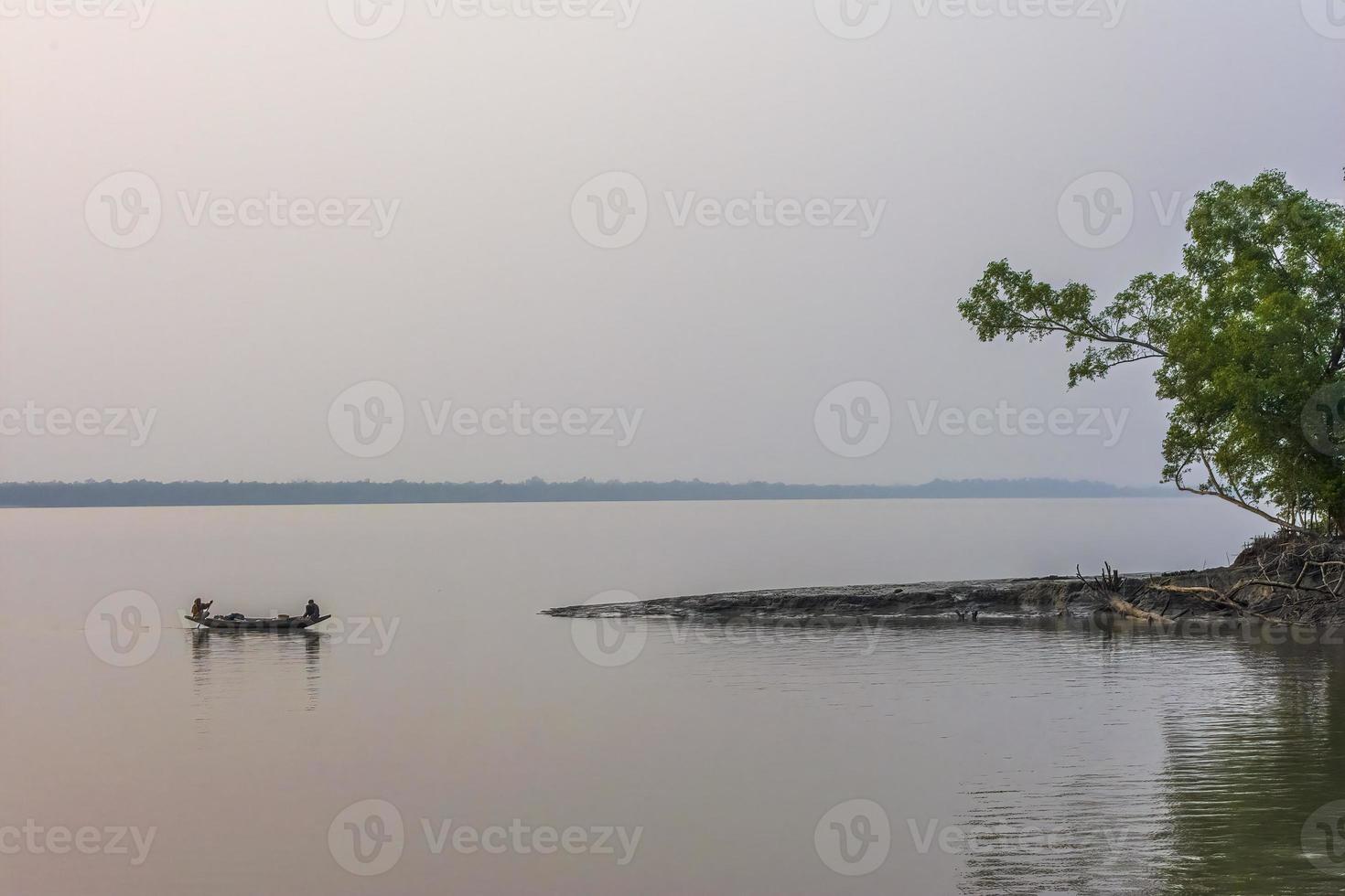 pescatori che pescano su una barca di campagna al tramonto, su un fiume, in bangladesh sundarbans foto