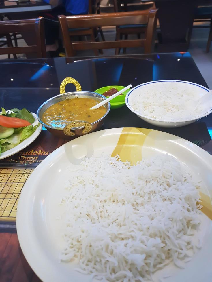 il satay di montone è un cibo tradizionale indiano. alla griglia con salsa di soia e salsa di arachidi. con riso nel piatto. con pomodori e cipolle. foto