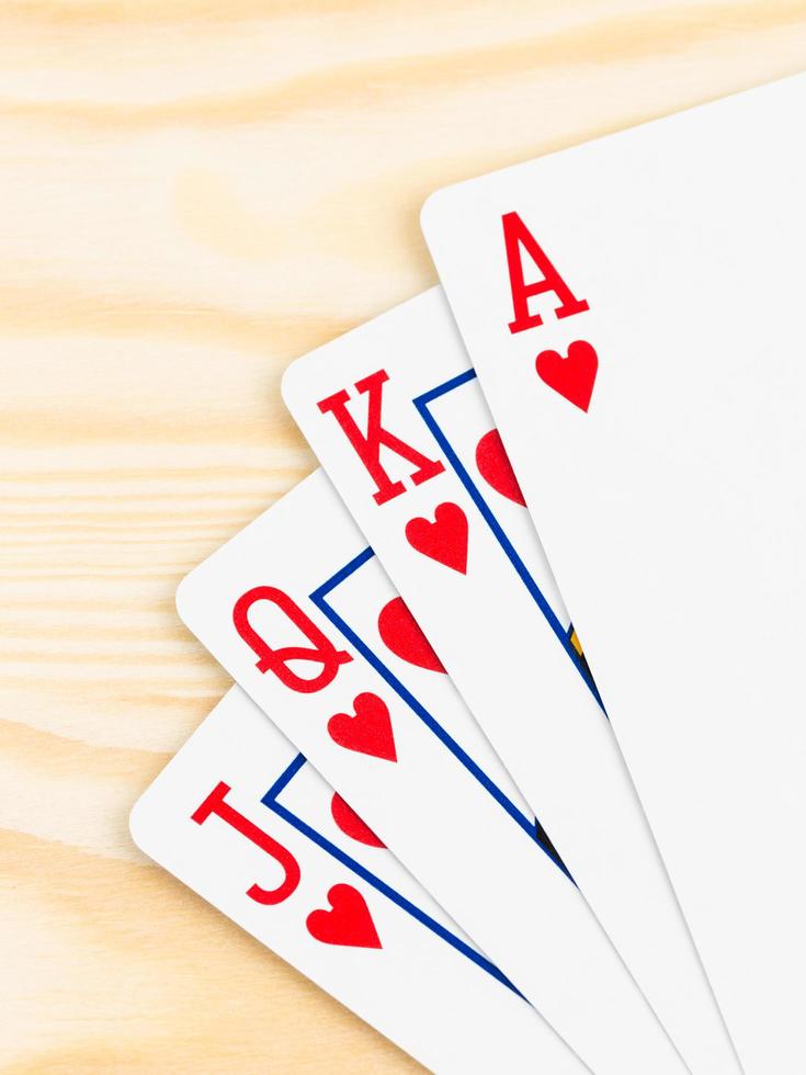 carte da gioco poker scala reale su fondo di legno foto