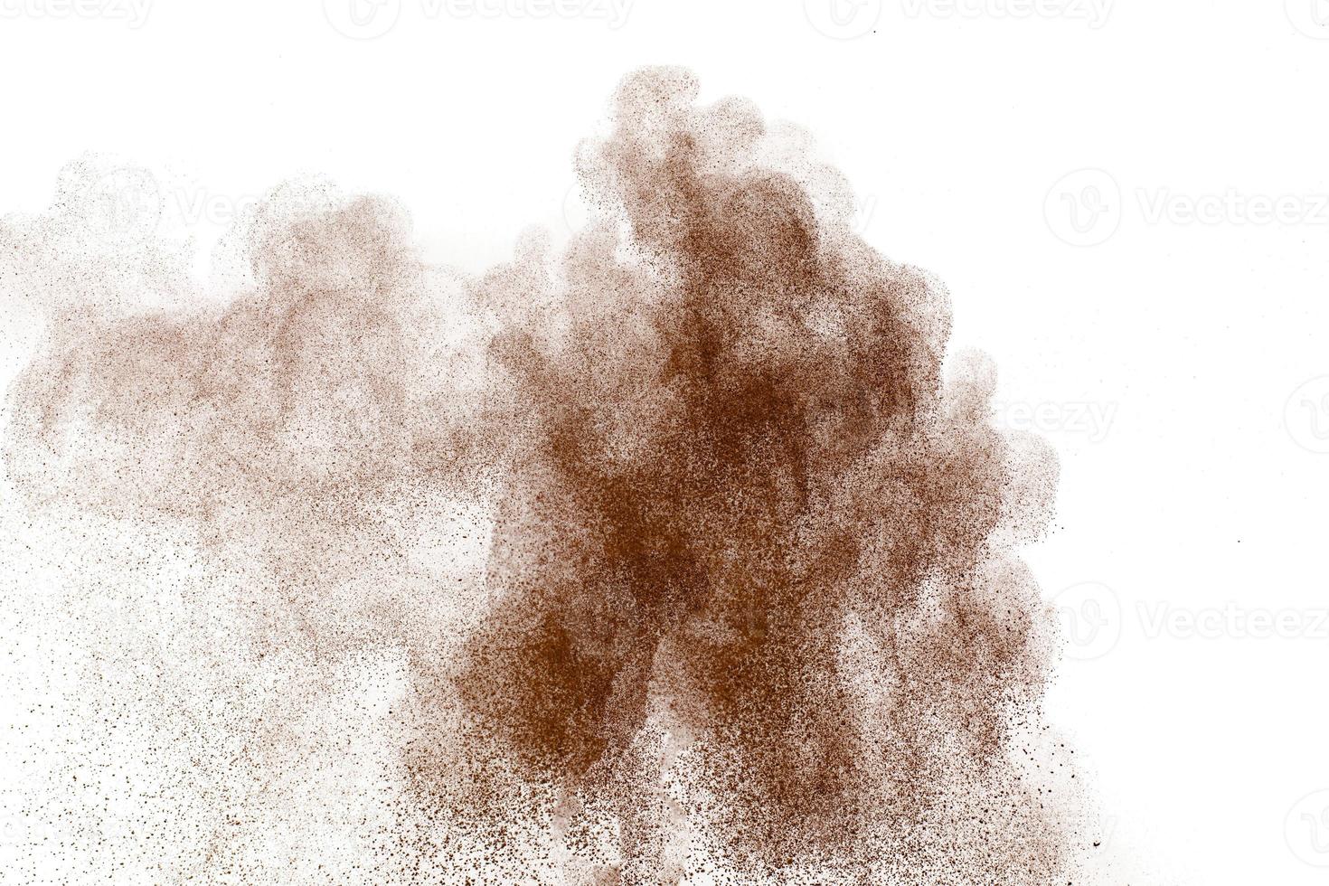 polvere marrone che esplode nuvola. particelle marroni schizzate su sfondo bianco. foto