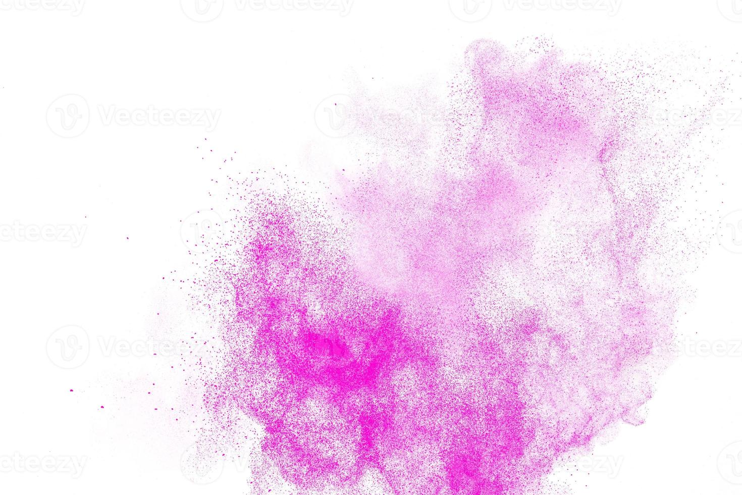 le particelle di polvere rosa spruzzano su sfondo bianco. foto