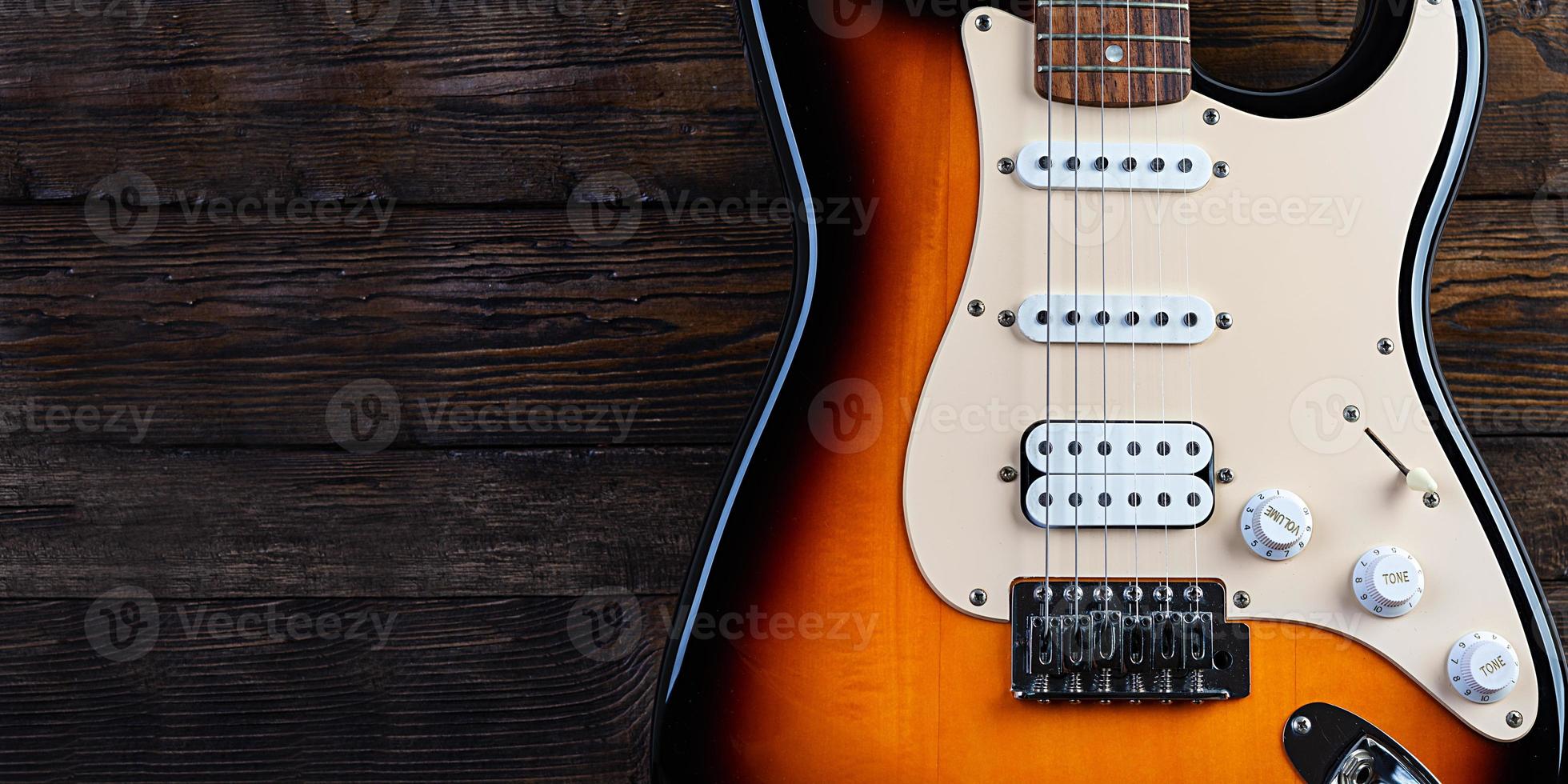 primo piano sulla chitarra elettrica sul vecchio fondo di legno dell'annata foto