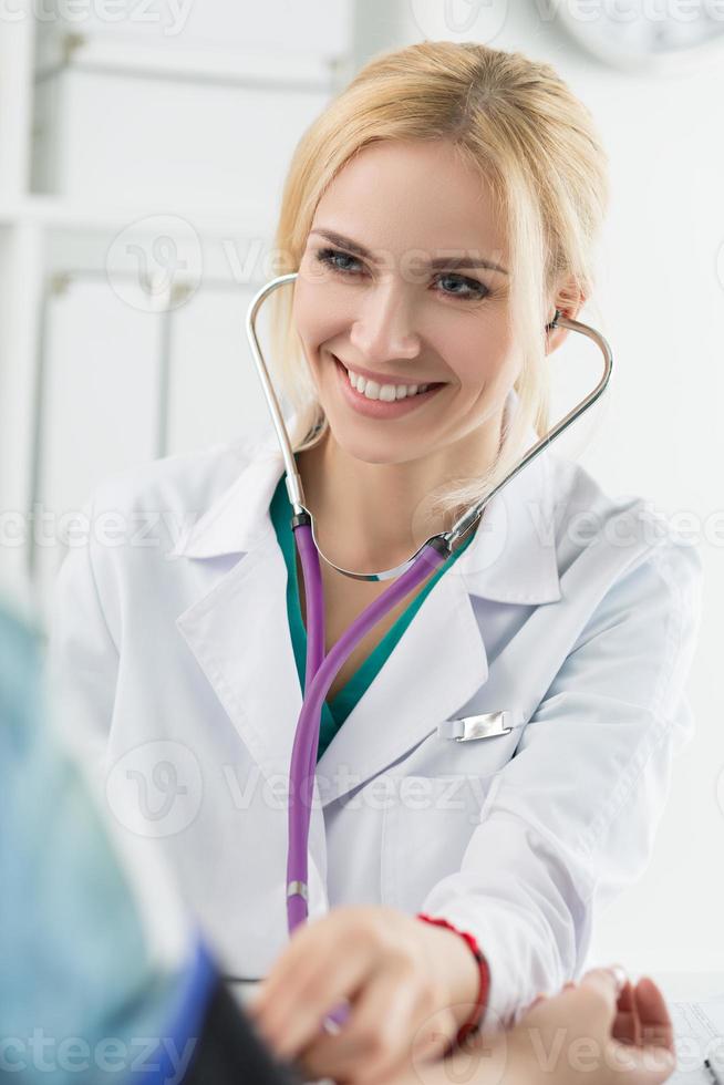 medico di medicina femminile che misura la pressione sanguigna foto