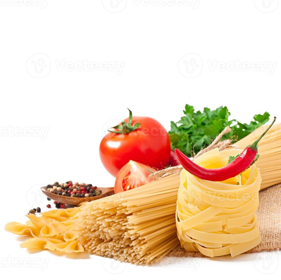 spaghetti di pasta, verdure, spezie isolate su bianco foto