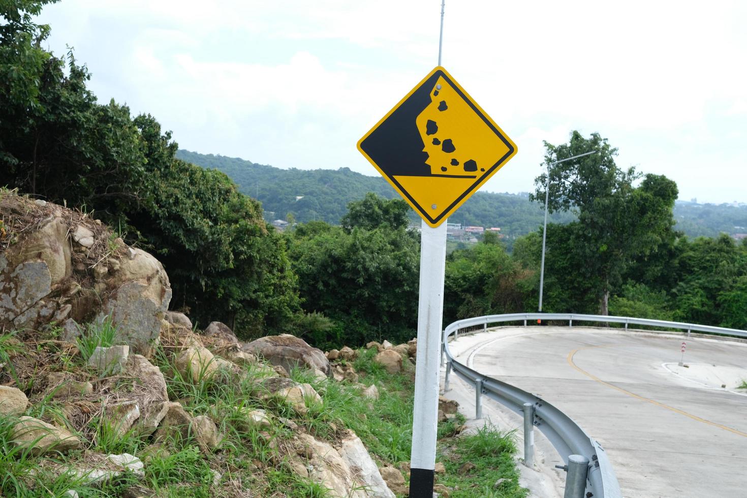 segnale stradale di caduta di pietra di avvertimento sulla strada di montagna. foto