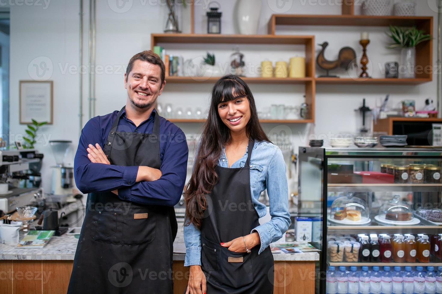 ritratto del proprietario sorridente in piedi al suo caffè. proprietario del caffè in piedi davanti alla caffetteria per accogliere il cliente e aprire la caffetteria al mattino. foto