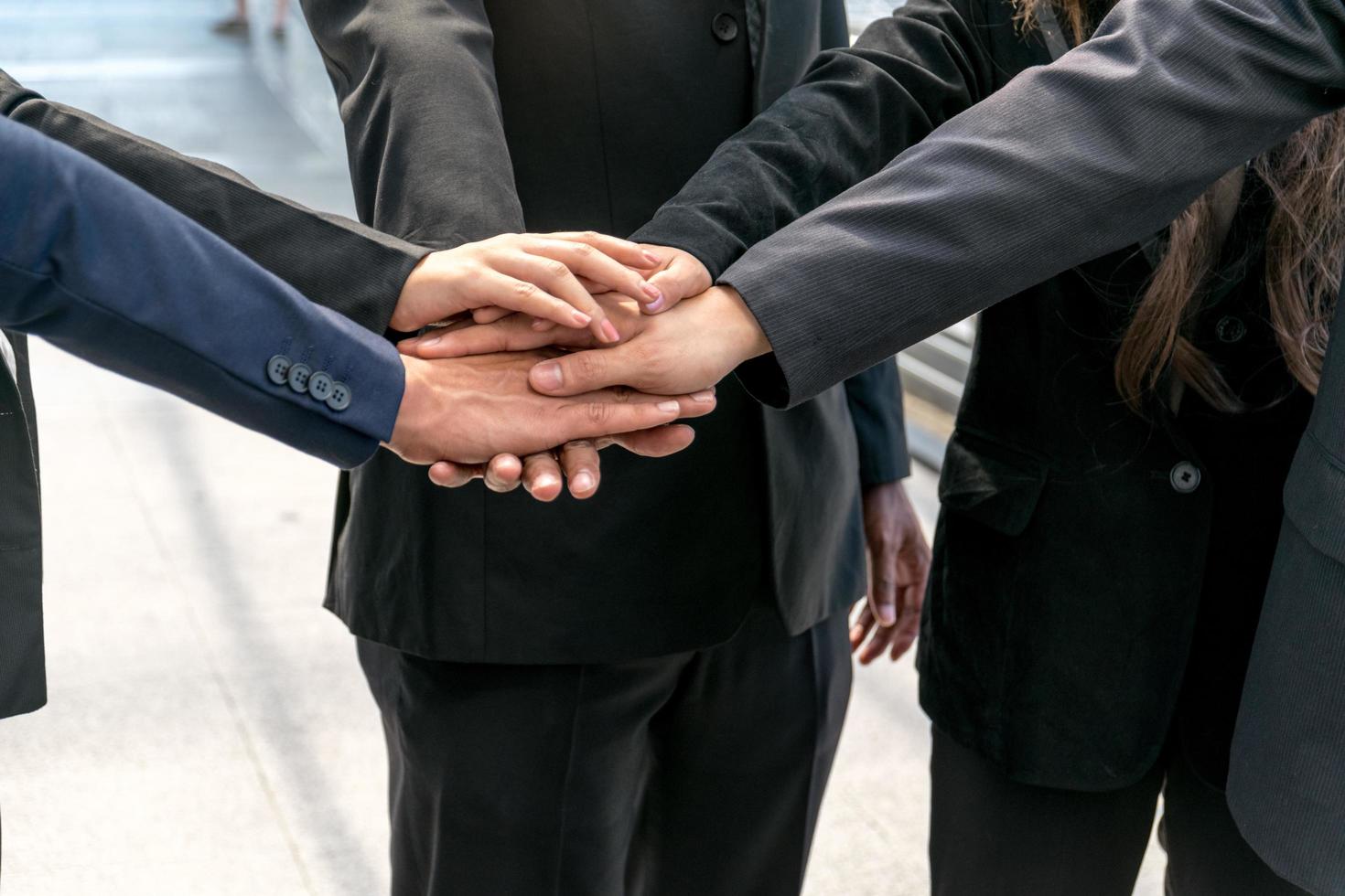 gruppo di uomini d'affari che si uniscono per mano. concetto di lavoro di squadra. foto