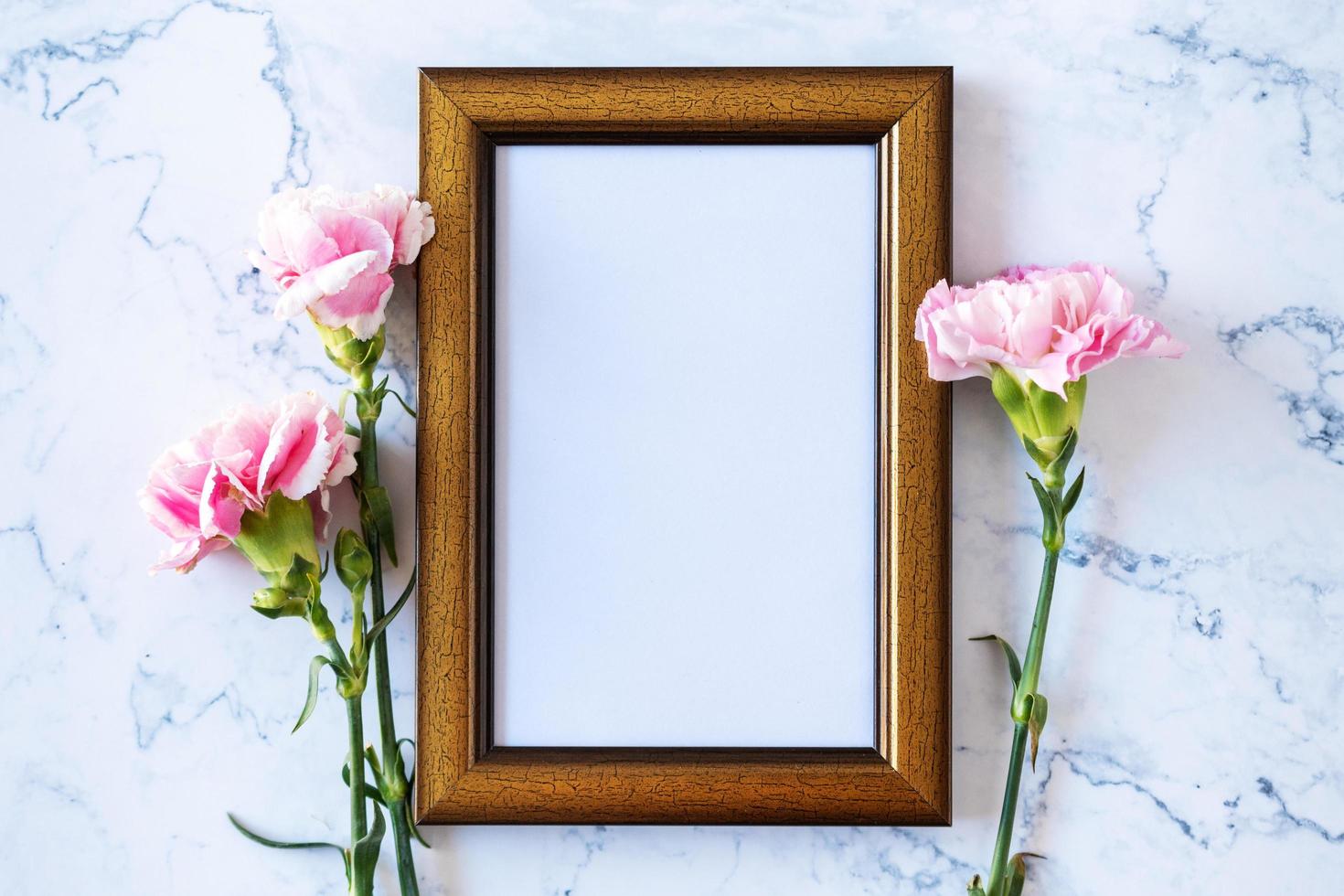 fiore di garofano su cornice vuota su sfondo marmo, San Valentino, festa della mamma o sfondo di compleanno foto