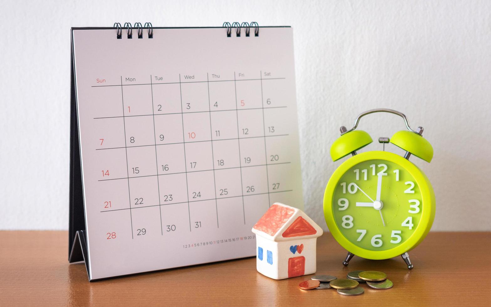 calendario e casa sul tavolo. giorno di acquisto o vendita di una casa o pagamento per affitto o prestito. foto