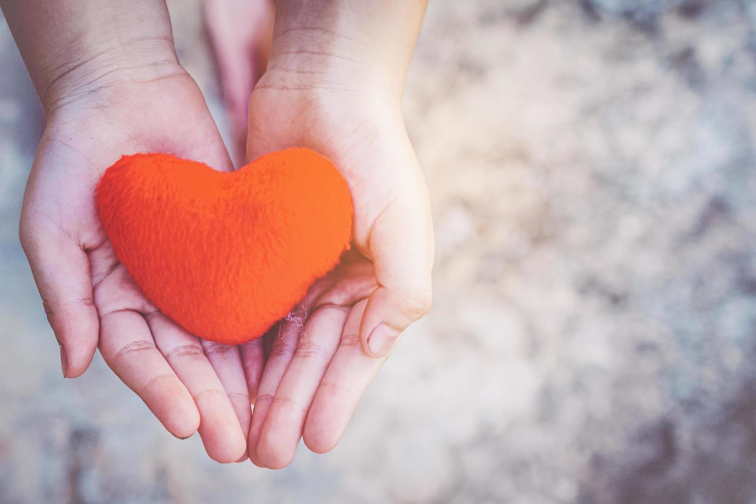 mani di bambino piccolo che tengono il cuore foto