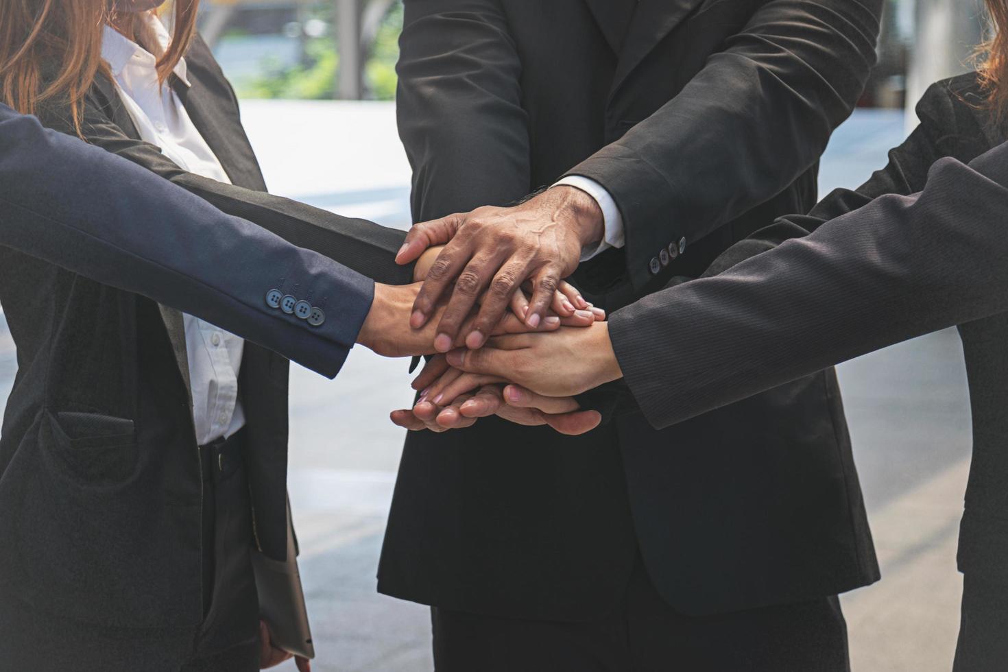 gruppo di uomini d'affari che si uniscono per mano. concetto di lavoro di squadra. foto