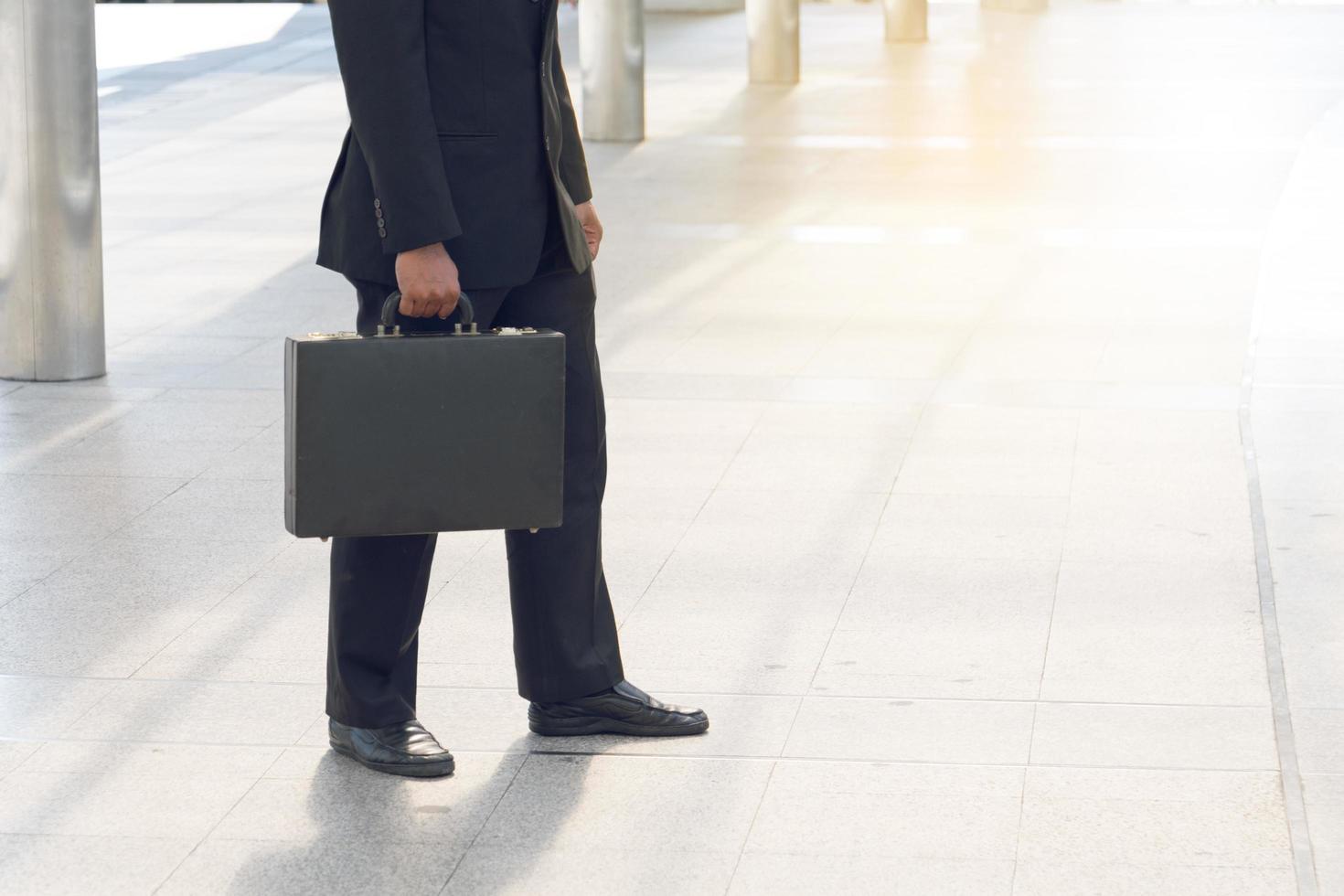 uomo d'affari che tira una borsa in una grande città. foto