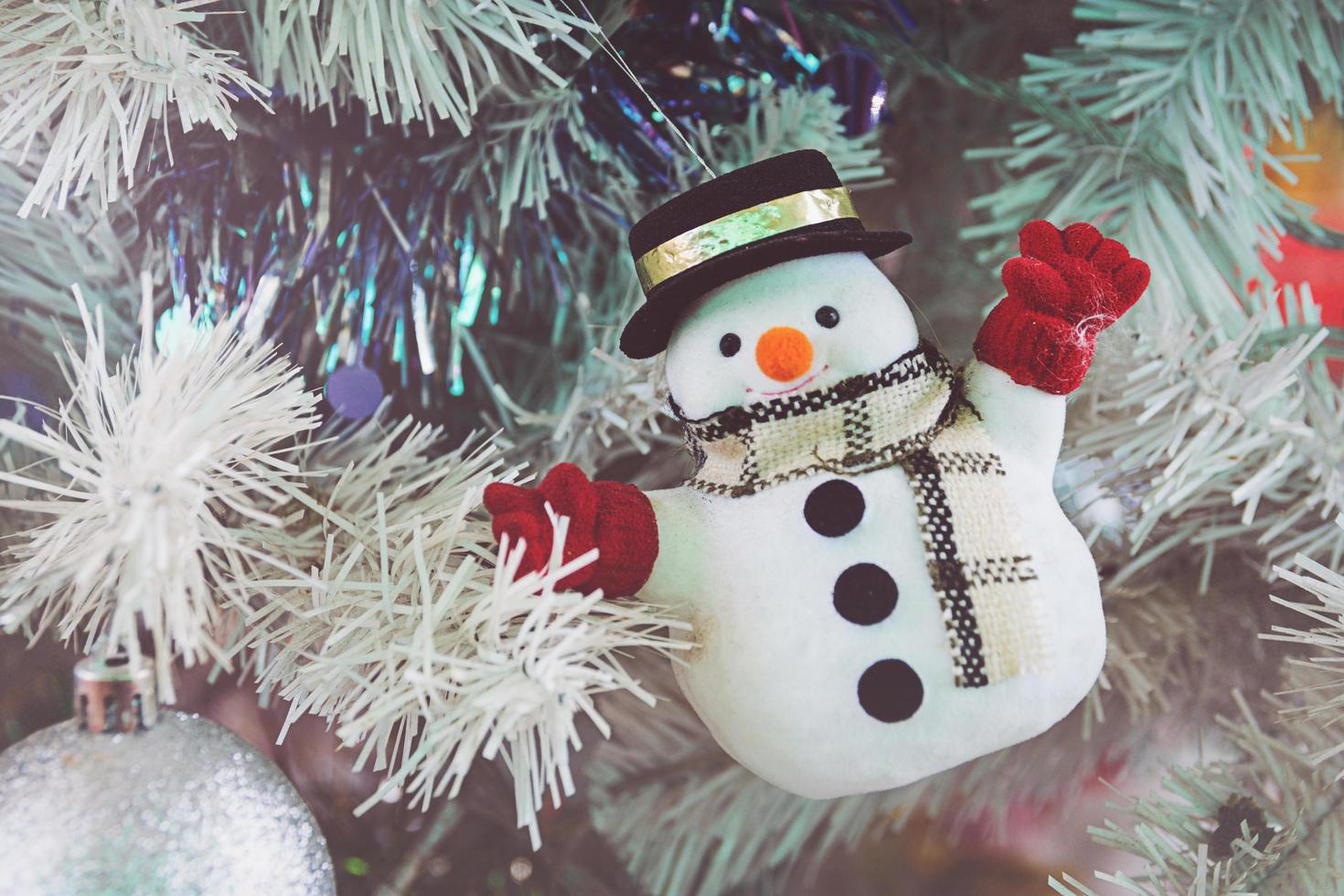 pupazzo di neve su un albero di Natale verde per il festival di capodanno foto