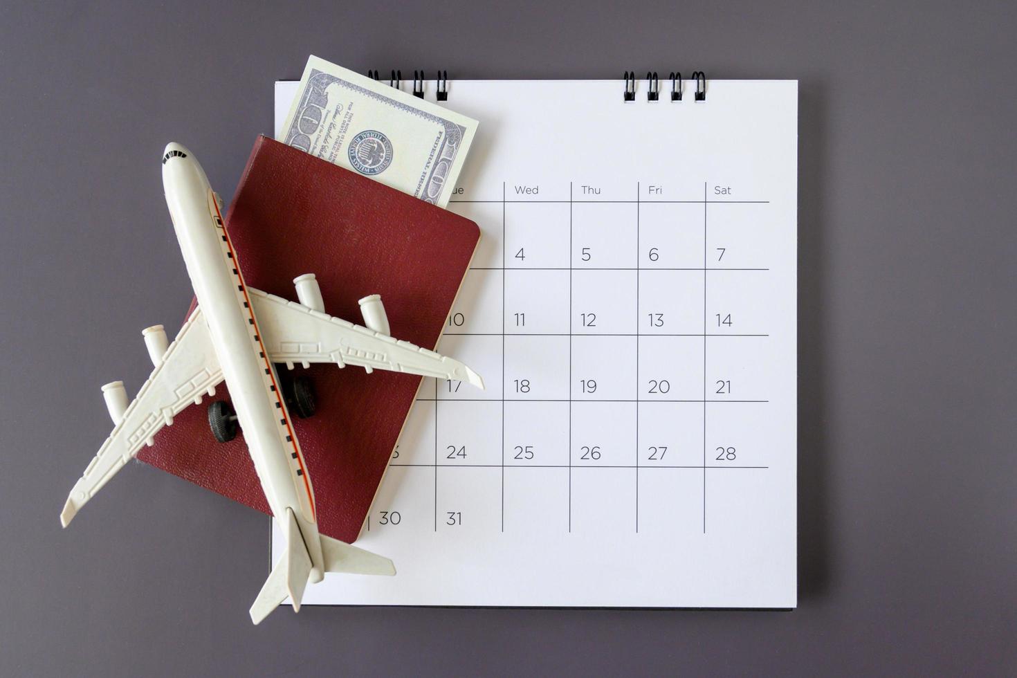 modello di aeroplano con calendario cartaceo. pianificare il viaggio foto