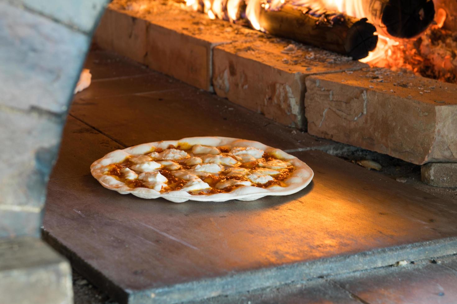 pizza in crosta sottile cotta nel forno a legna foto