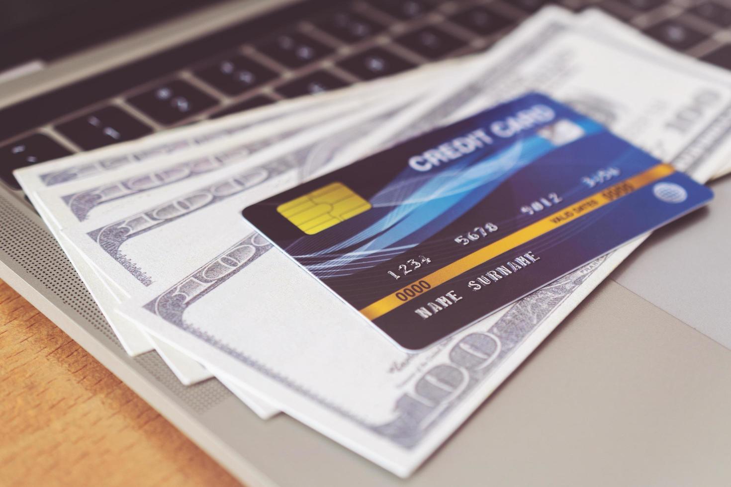 carta di credito e denaro sulla tastiera di un computer. concetto di shopping online, pagamento online foto