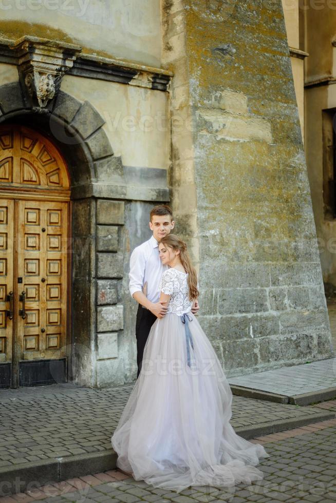 sposi di lusso che abbracciano e si baciano alla luce del sole. splendida sposa e sposo alla moda in un momento emotivo tenero sensuale. foto in bianco nero. ritratti