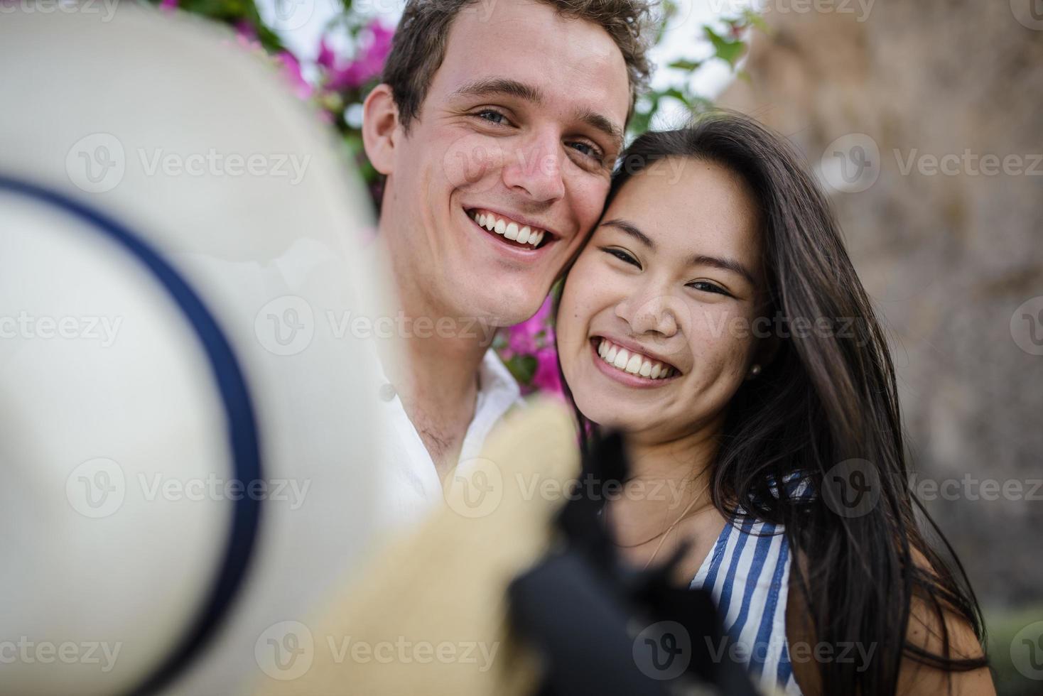 giovane coppia che cammina sullo sfondo di un grande cespuglio foto