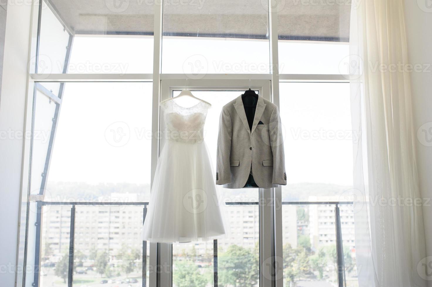 giacca da sposo e abito da sposa sullo sfondo di una grande finestra. foto