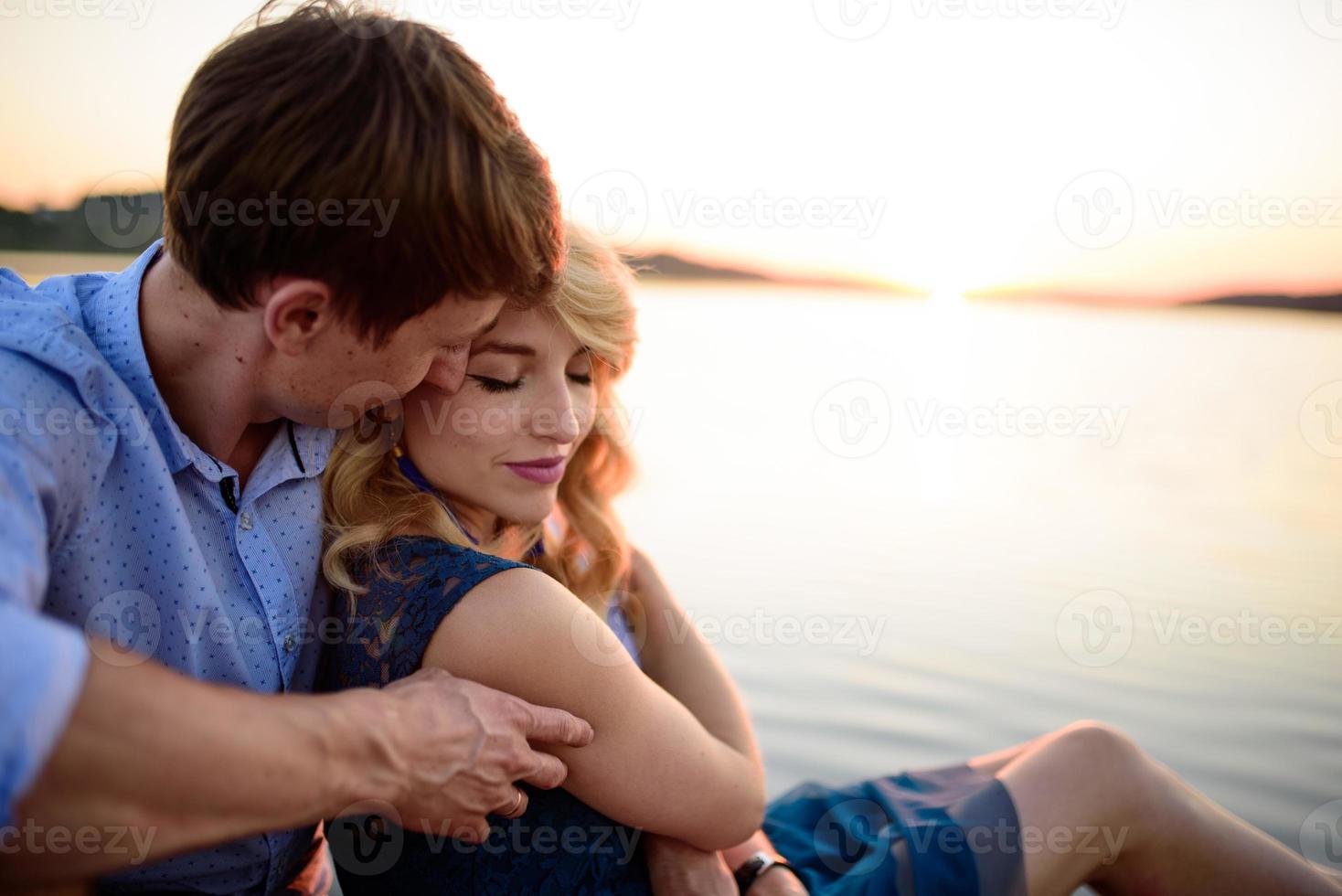 uomo e donna sul molo vicino al lago. foto