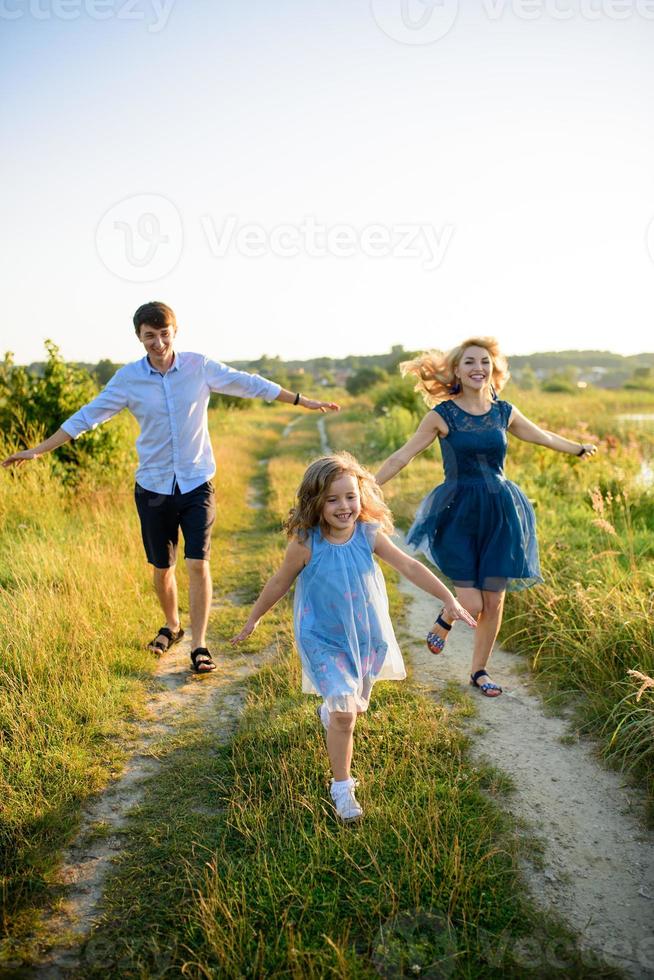 papà mamma e figlia si divertono insieme nella natura. foto