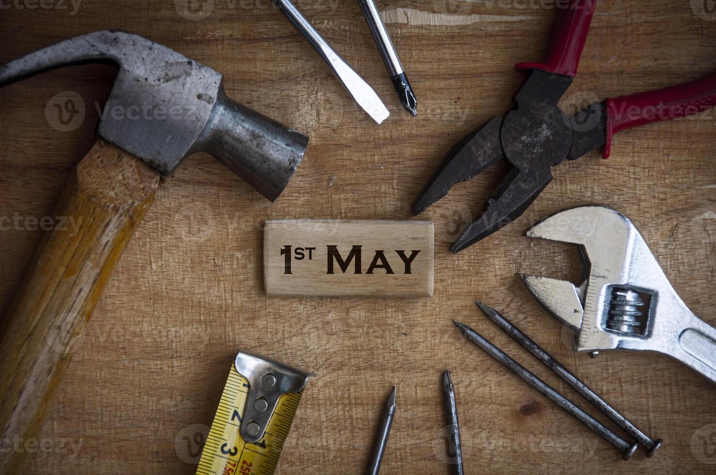 testo su blocco di legno - 1 maggio con sfondo di strumenti di lavoro. foto