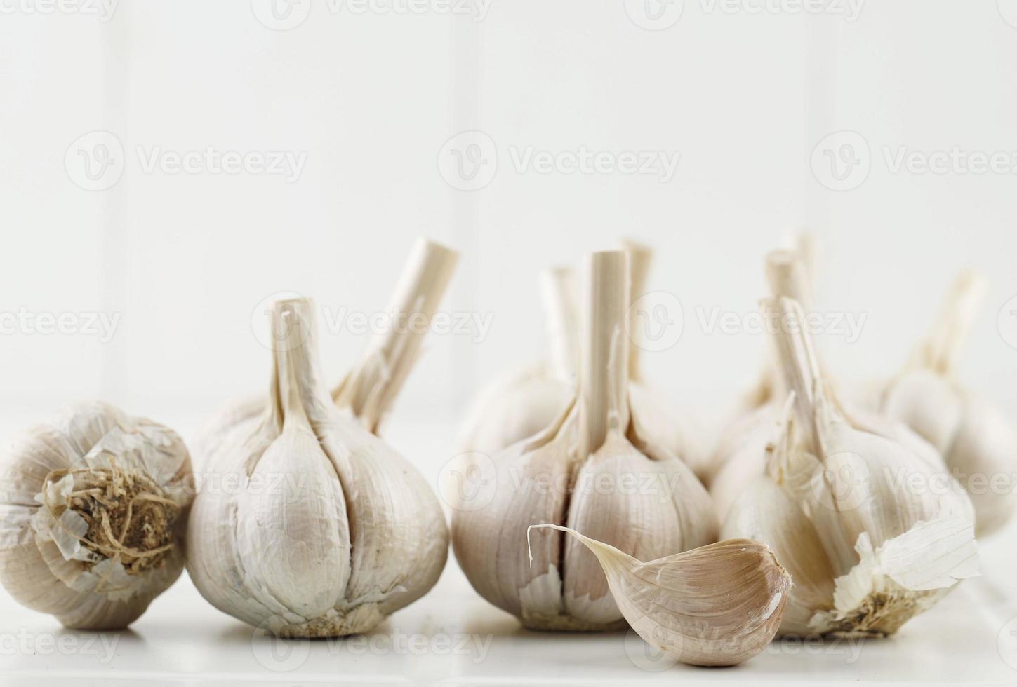 primo piano di bulbi d'aglio su tavola di legno con garlics sfocatura dello sfondo. foto