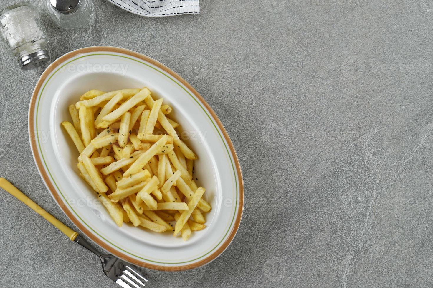 patatine fritte in una ciotola su uno sfondo di tavolo di cemento foto