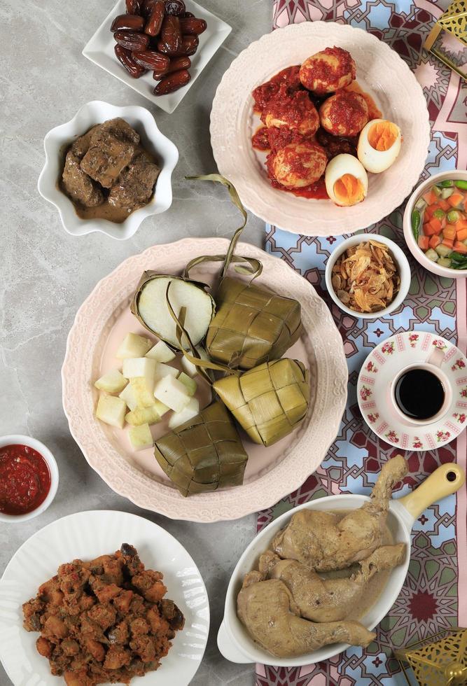 ketupat lebaran. tradizionale piatto celebrativo di torta di riso o ketupat con vari contorni, popolare servito durante le celebrazioni dell'eid foto