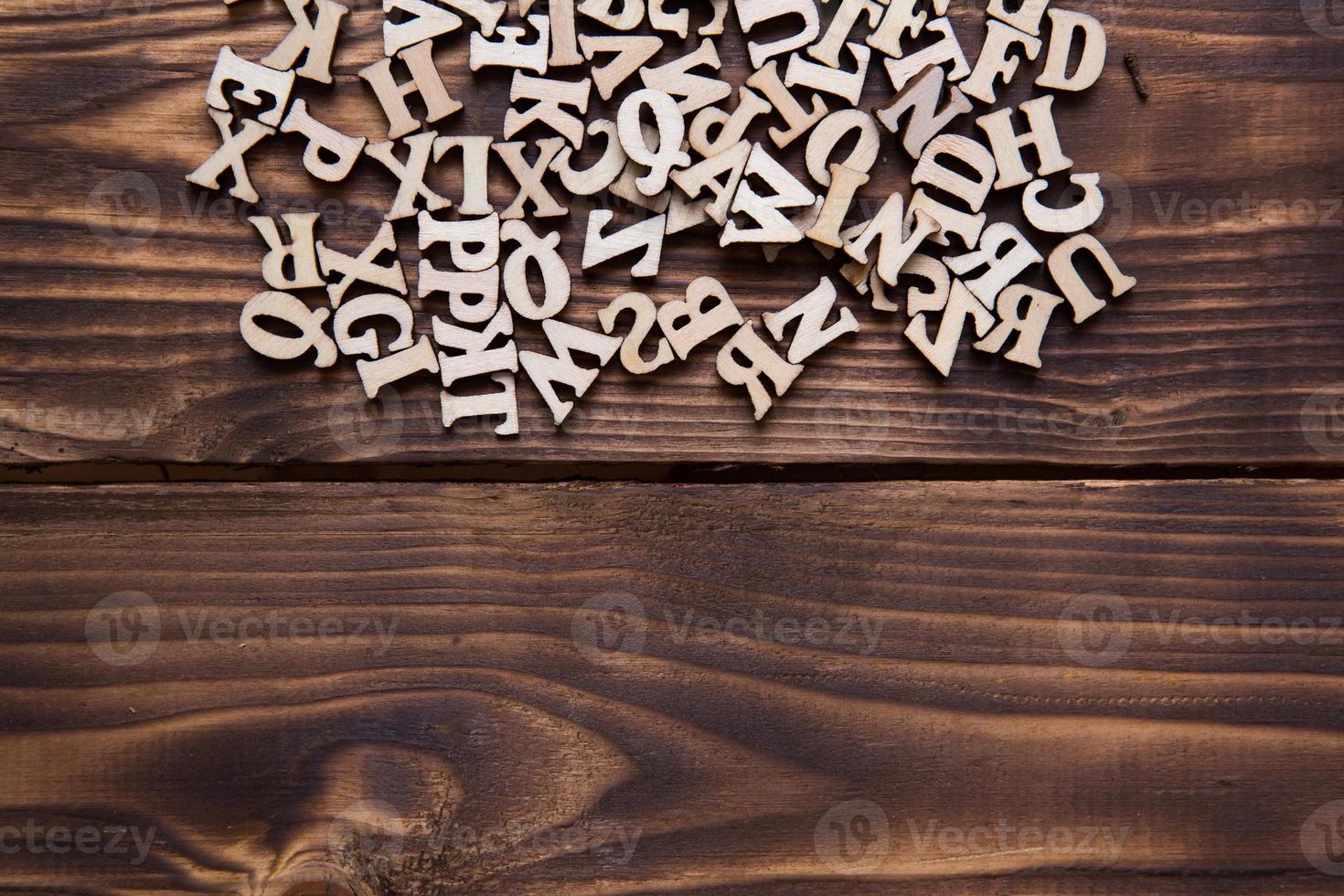 lettere dell'alfabeto inglese su uno sfondo di legno scuro. il concetto di educazione, giochi di parole, ricamo. spazio per il testo foto