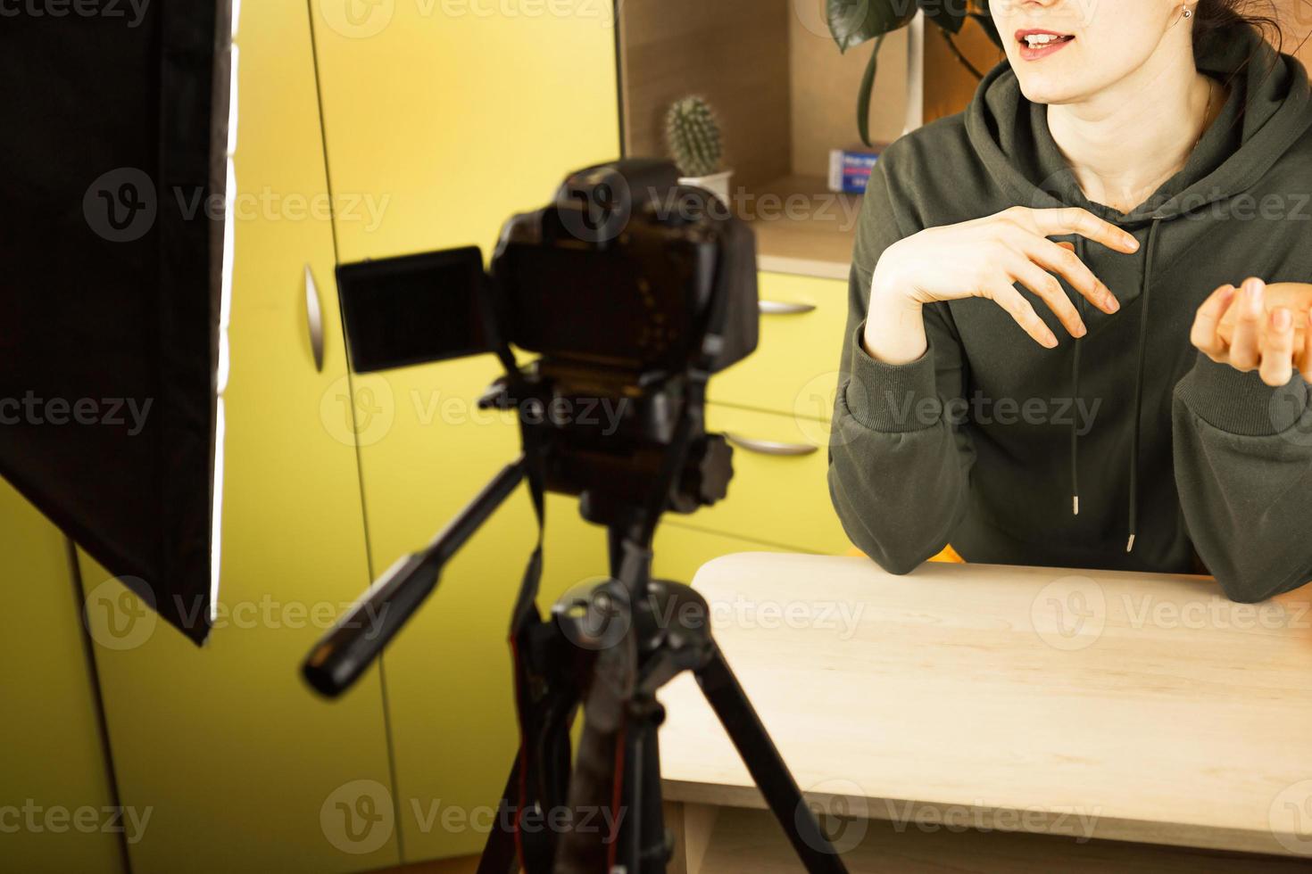 una donna conduce una trasmissione in diretta vlog, registra un video su una telecamera da casa. comunicazione a distanza, nuova realtà, blog, videoconferenza foto