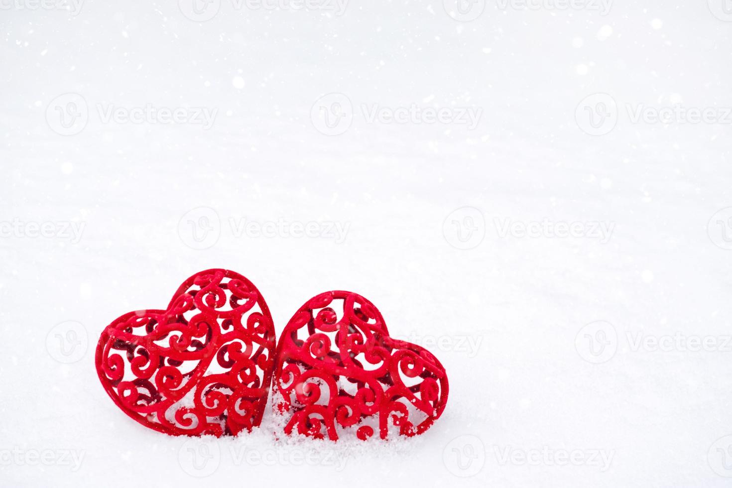 due cuori rossi nella neve - un biglietto di auguri per San Valentino, la vacanza di tutti gli innamorati il 14 febbraio. copia spazio. invito a un appuntamento, amore, incontri foto