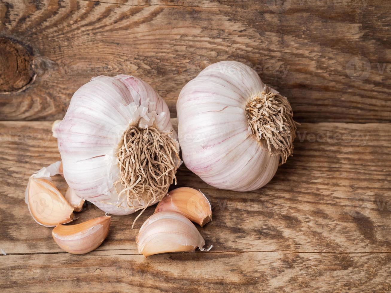 tuberi interi e spicchi d'aglio su un tavolo di legno, un antisettico naturale. foto