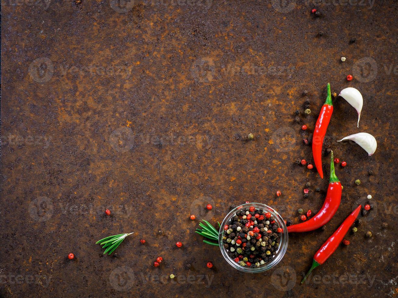 baccelli e piselli di peperoncino rosso piccante, spicchio d'aglio su sfondo di metallo arrugginito scuro, vista dall'alto, spazio per la copia foto
