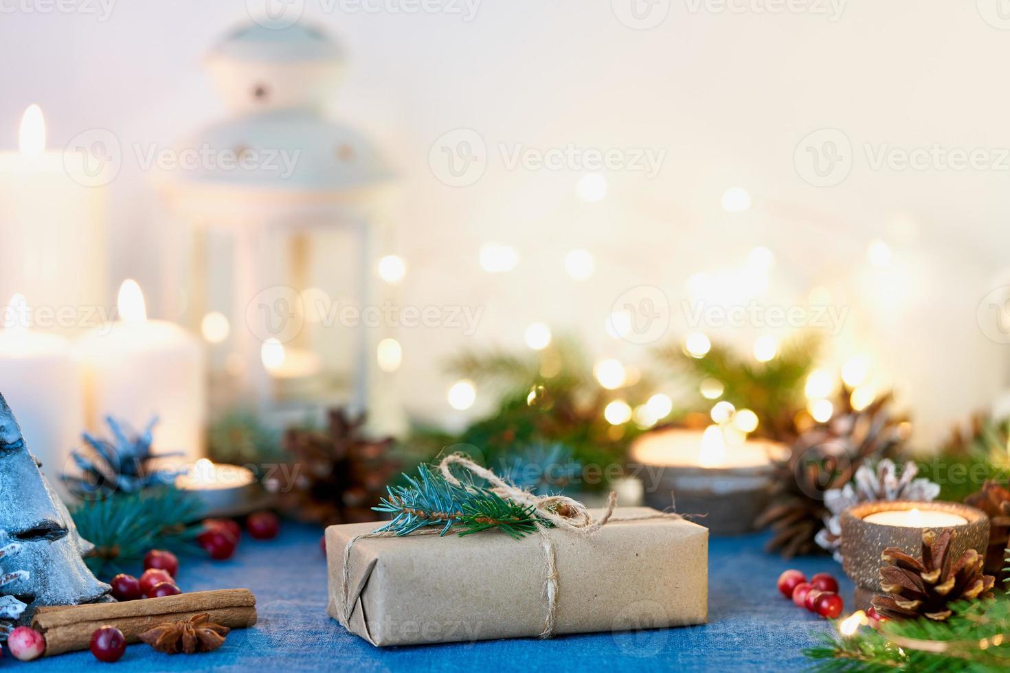 sfondo di natale con confezione regalo e decorazioni, candele e ghirlande di luci. foto