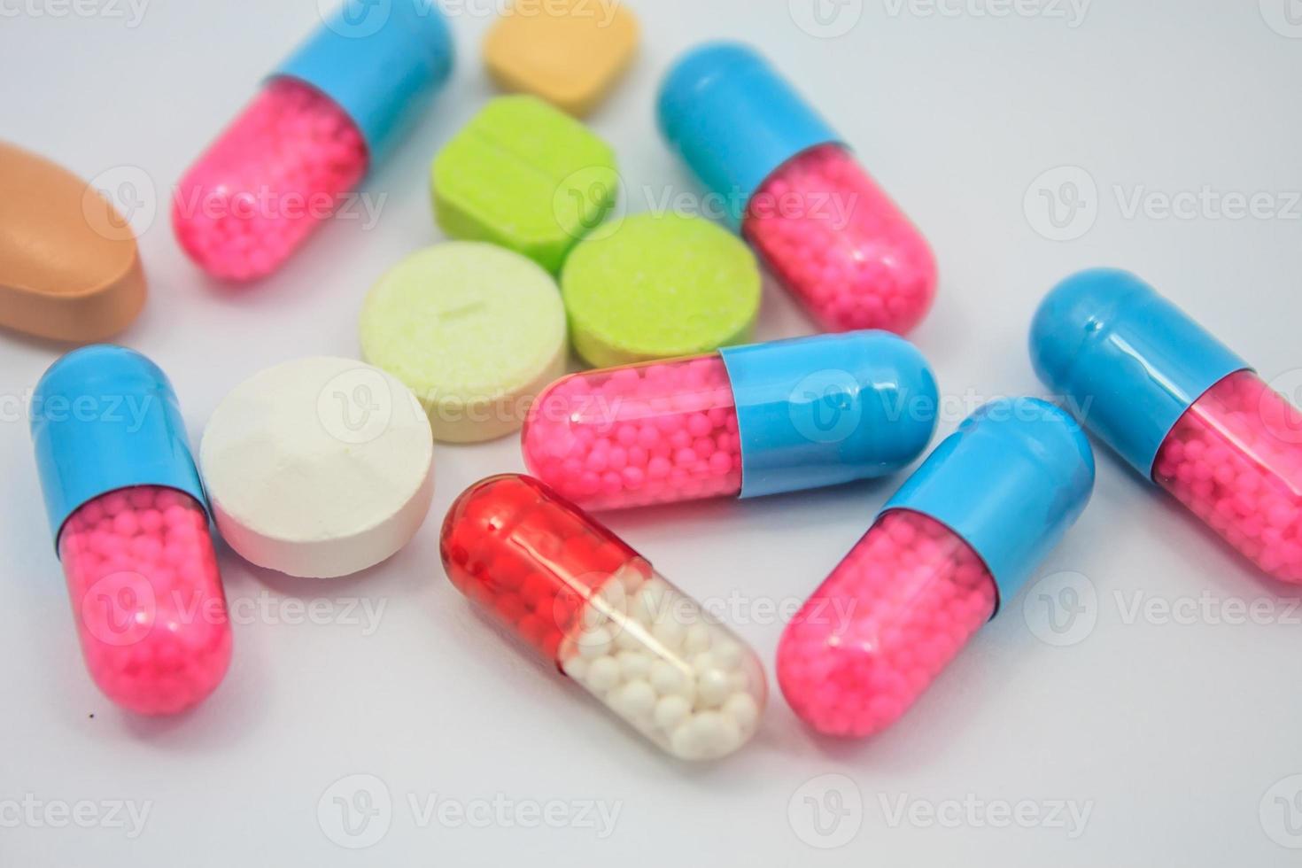 pillole colorate, compresse e capsule su sfondo bianco foto