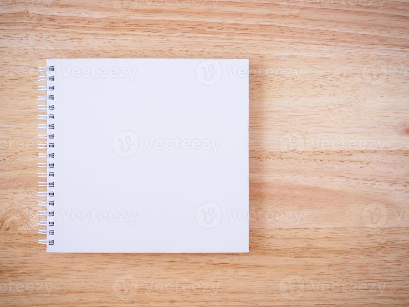 quaderno con copertina bianca su sfondo marrone scrivania in legno foto