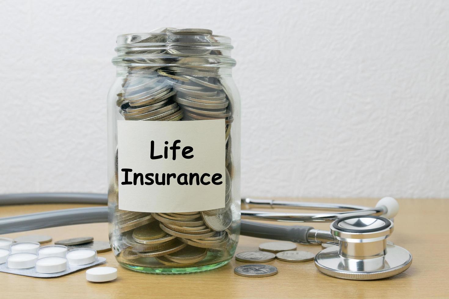 risparmio di denaro per l'assicurazione sulla vita nella bottiglia di vetro foto