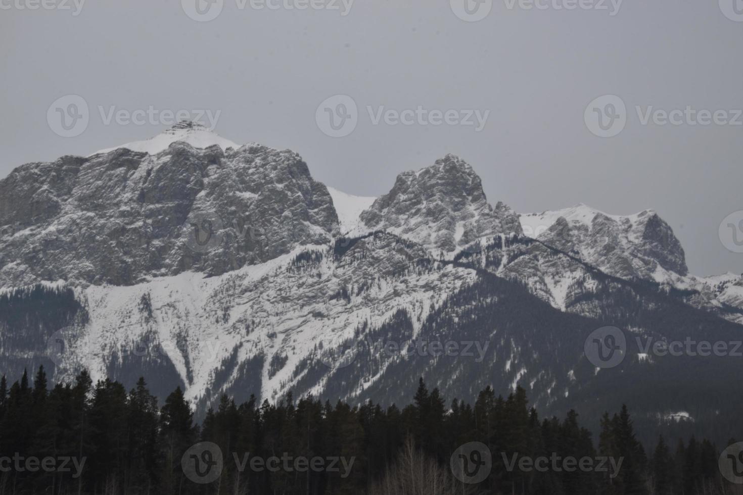 montagne rocciose innevate con cielo grigio nebbioso foto