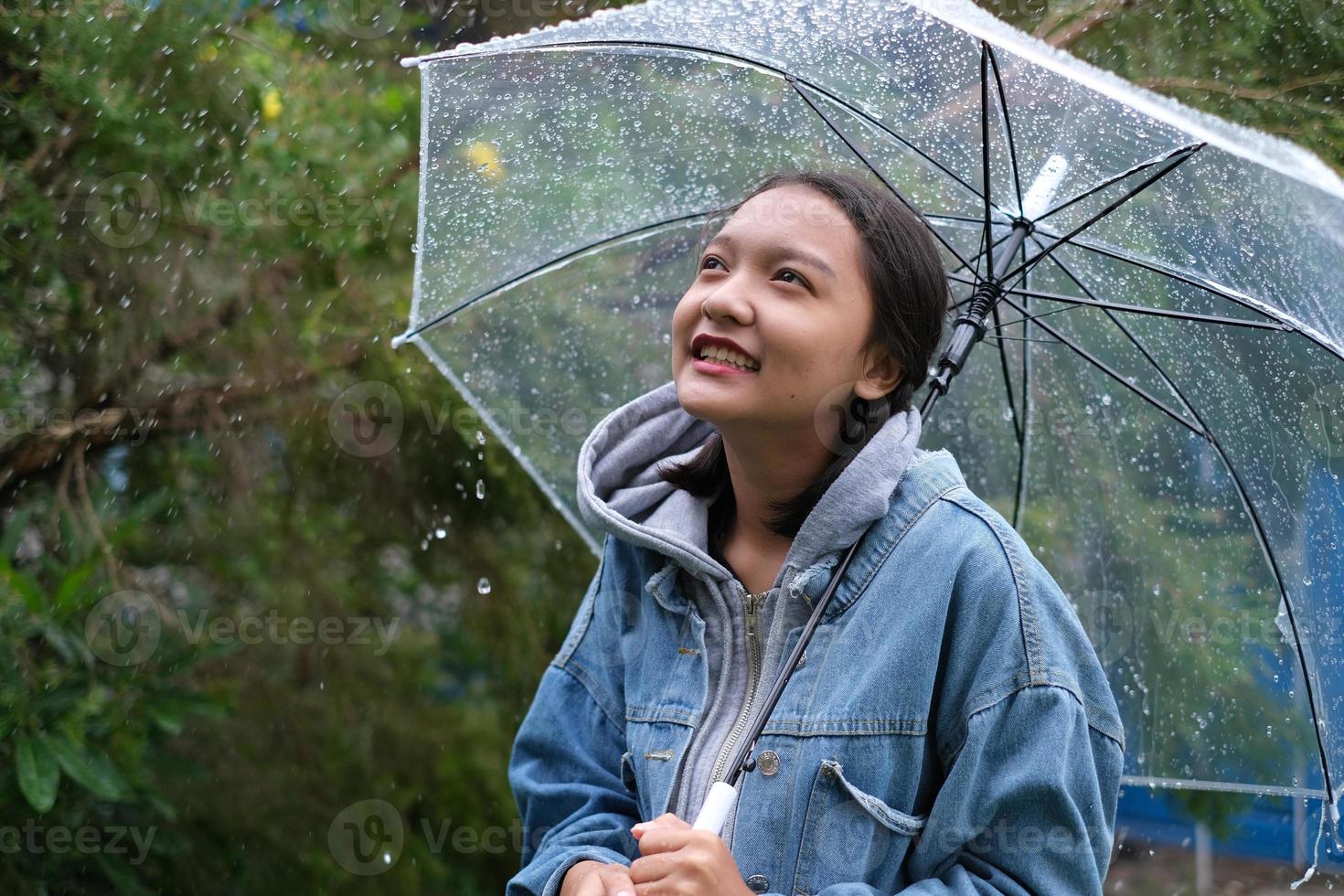 sorriso ragazza divertendosi sotto la pioggia. foto