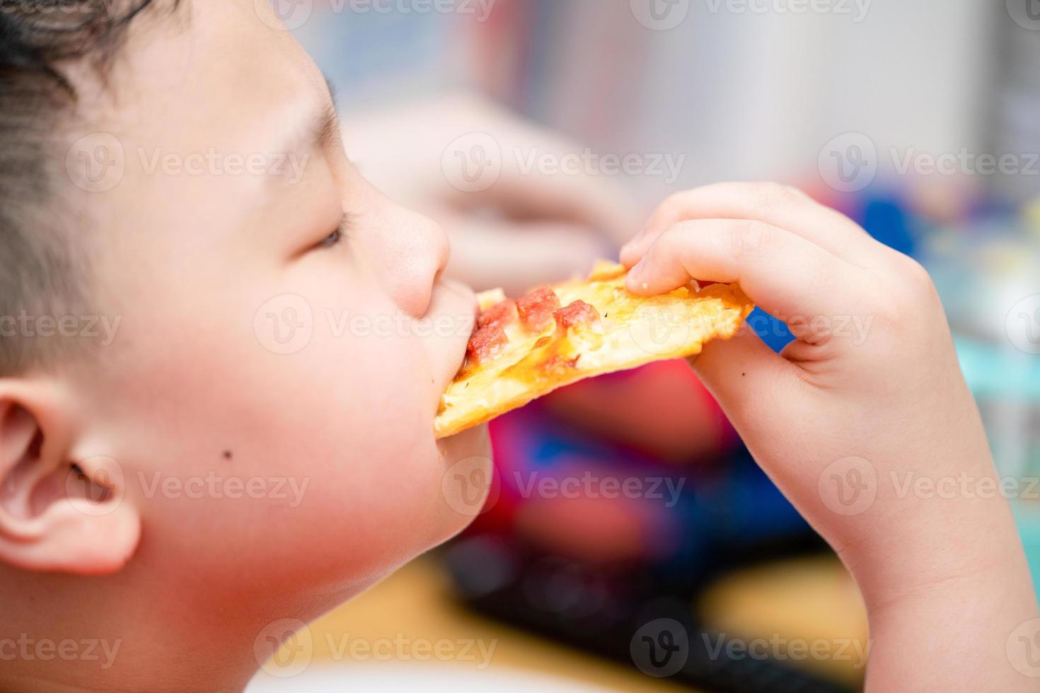 il bambino mangia la pizza foto