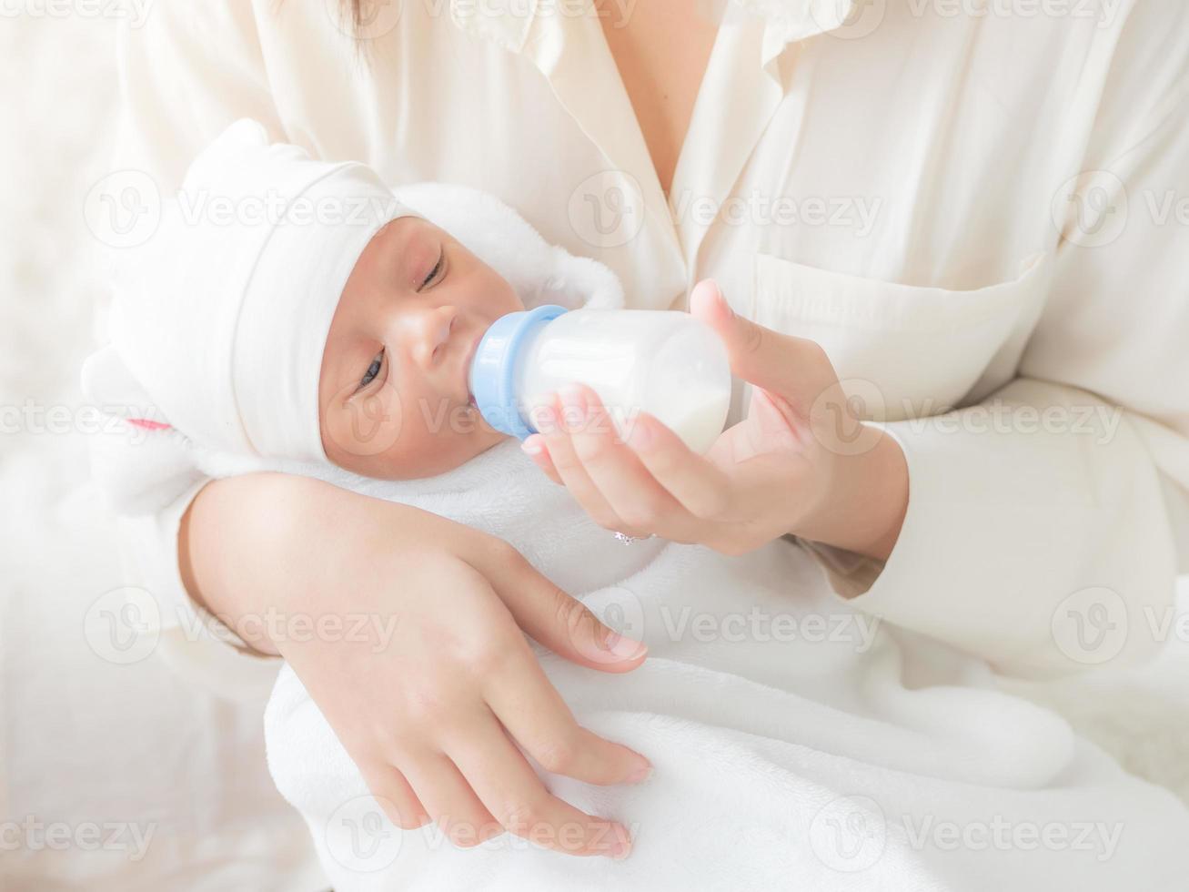 una bella donna asiatica, che porta il suo neonato con amore e affetto foto