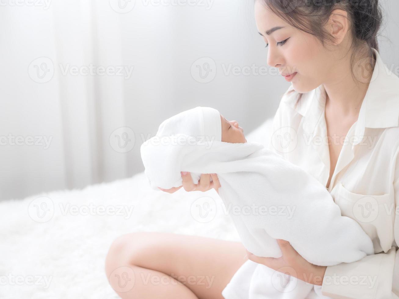 una bella donna asiatica portava felice il suo neonato foto