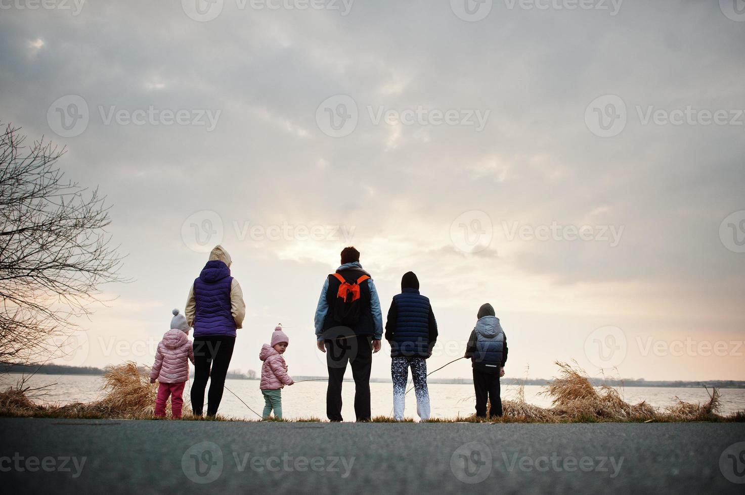 ritorno della famiglia con quattro bambini in riva al lago. foto