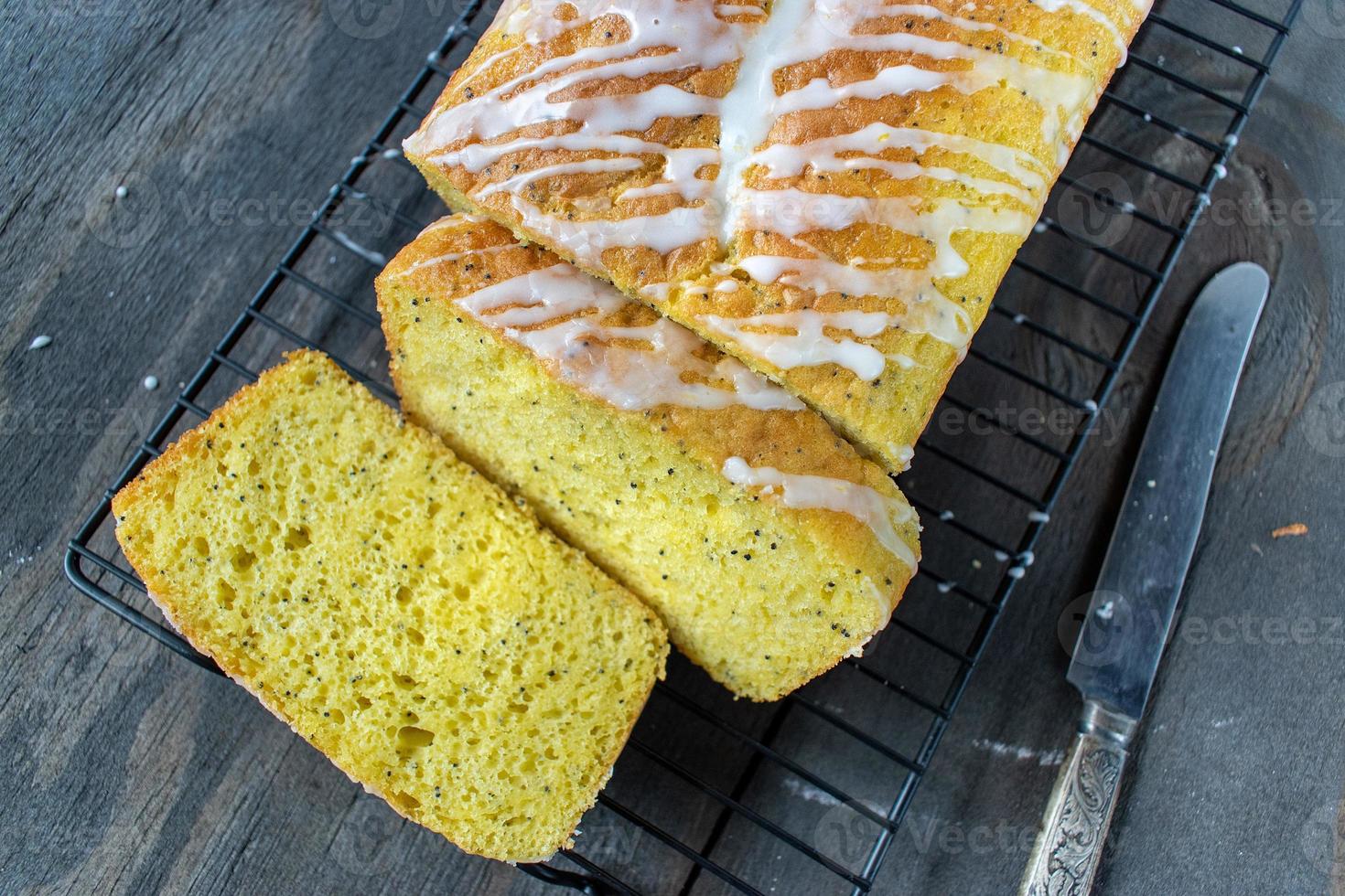 pagnotta di torta di semi di papavero al limone al forno con glassa bianca pioggerella piatta foto